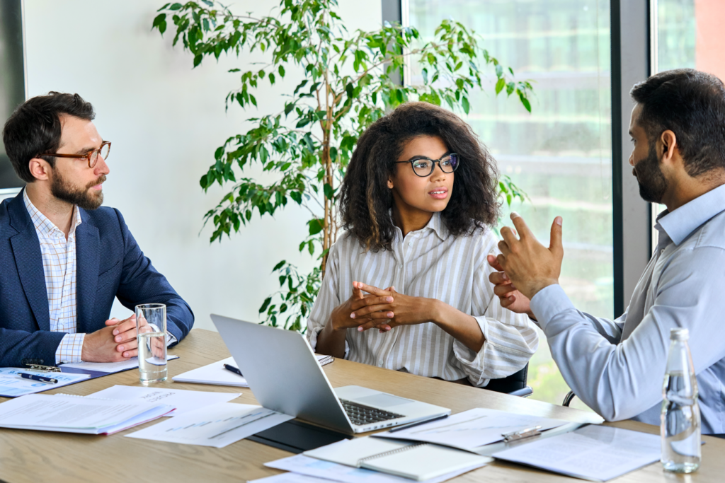 Two men and woman engaged in professional discussion at board tabel in modern office