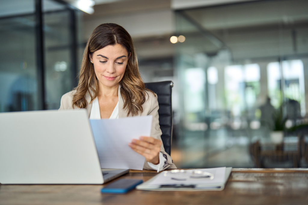 A professional woman in a business suit reviewing a document.