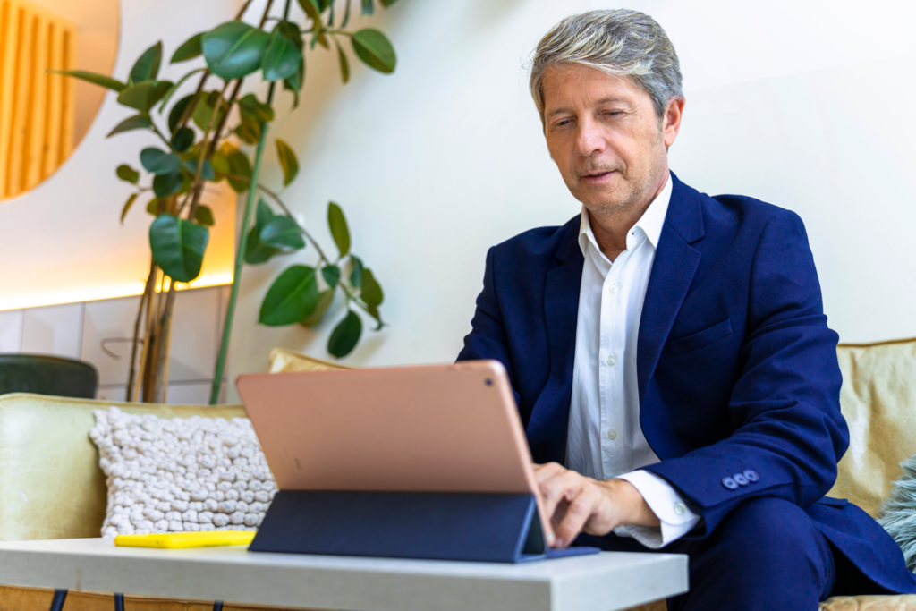 Professional man using laptop on couch.