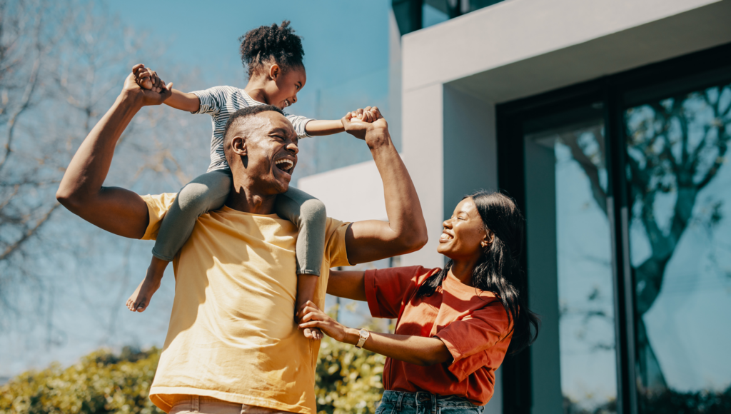 A happy family playing in the yard, laughing and enjoying the sunshine.